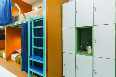 a room with bunk beds with blue and white cabinets at Aekkeko hostel in Phuket Town