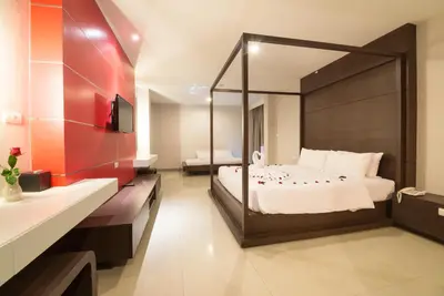 a bedroom with a large bed and a large mirror at Alfresco Phuket Hotel in Patong Beach