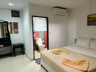 a bedroom with a bed and a bathroom with a toilet at Bang sit Guest House in Phi Phi Don