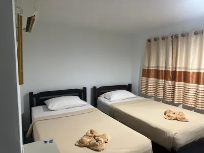 two beds with towels on them in a room at Bang sit Guest House in Phi Phi Don