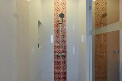 a bathroom with a shower with a glass door at Tinidee Golf Resort Phuket in Kathu