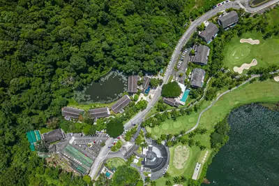 an overhead view of a park with a road and water at Tinidee Golf Resort Phuket in Kathu