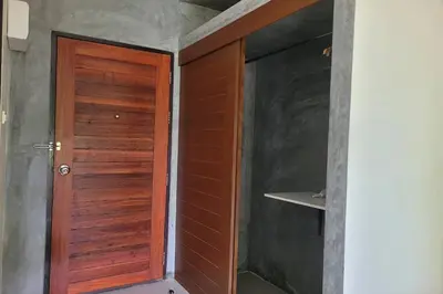 a wooden door in the corner of a room at Snooze Inn Phuket - Free Shuttle to Bang Rong Pier in Ban Pa Khlok
