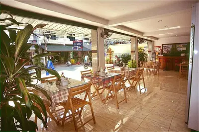 a restaurant with tables and chairs in a building at J Mansion in Ao Nang Beach