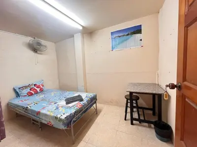 a small room with a bed and a table at J Mansion in Ao Nang Beach