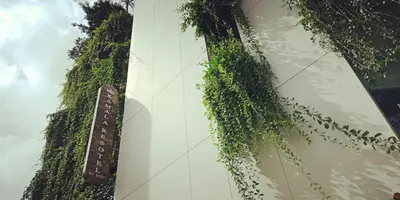 a building with plants growing on the side of it at Kamala Resotel, SHA Extra Plus in Kamala Beach
