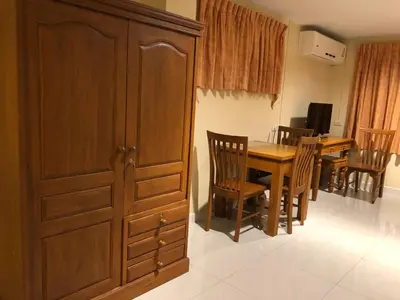 a dining room with a wooden cabinet and a table and chairs at Naithon Beach Residence in Nai Thon Beach