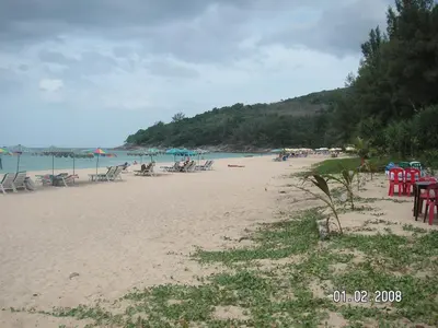 a beach with tables and chairs and the ocean at Naithon Beach Residence in Nai Thon Beach