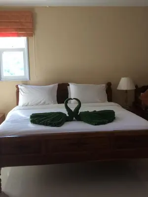 a bed with a green ribbon on top of it at Naithon Beach Residence in Nai Thon Beach