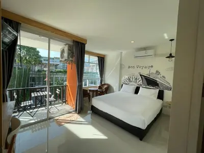 a bedroom with a bed and a balcony at Dwell Phuket Airport Hotel at Naiyang in Nai Yang Beach