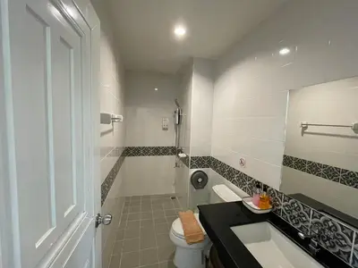 a bathroom with a shower and a sink and a toilet at Dwell Phuket Airport Hotel at Naiyang in Nai Yang Beach
