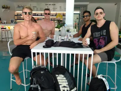 a group of men sitting around a table in a store at Borbaboom Phuket Poshtel & Hostel in Phuket Town