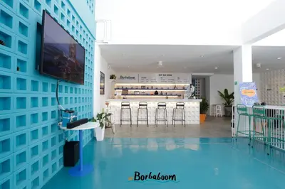 a living room with a blue wall and a tv at Borbaboom Phuket Poshtel & Hostel in Phuket Town