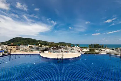 a large swimming pool with a view of the ocean at Amata Patong in Patong Beach