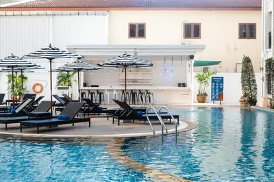 a hotel swimming pool with chairs and umbrellas at Amata Patong in Patong Beach