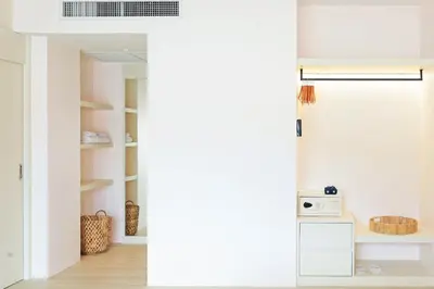a room with white walls and a kitchen with white shelves at Amata Patong in Patong Beach