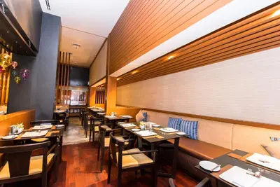 a dining room with wooden tables and chairs at ASHLEE Hub Hotel Patong in Patong Beach