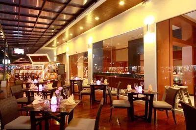 a restaurant with tables and chairs and a bar at ASHLEE Hub Hotel Patong in Patong Beach