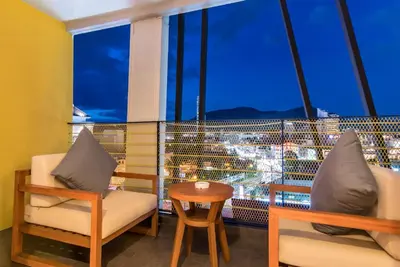 a room with a table and chairs and a large window at ASHLEE Hub Hotel Patong in Patong Beach
