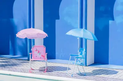 two chairs and umbrellas in front of a building at The Panwa Guesthouse, Phuket in Panwa Beach