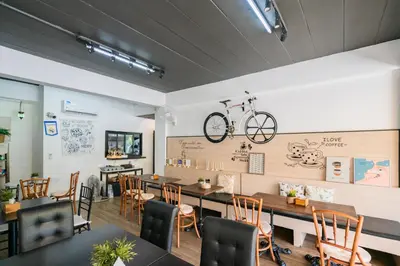 a dining room with a table and a bike on the wall at The Panwa Guesthouse, Phuket in Panwa Beach