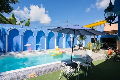 a pool with an umbrella and a rubber duck in a float at The Panwa Guesthouse, Phuket in Panwa Beach