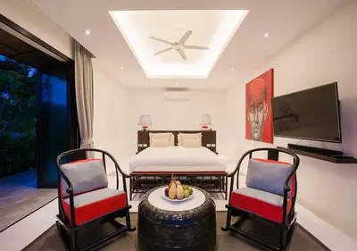 a bedroom with a bed and two chairs and a table at Bungalow VILLA Rumba in Ko Yao Noi