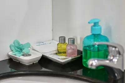 a bathroom counter with a sink and a bottle of soap at Ruen Buathong Boutique Hotel Patong Beach in Patong Beach