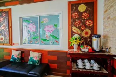 a room with a bench and a window with flowers at Ruen Buathong Boutique Hotel Patong Beach in Patong Beach