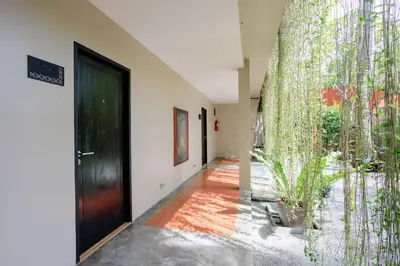 a hallway with a black door and a plant at Signature Phuket Resort in Chalong