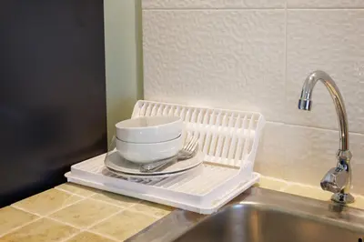 a white dish drying rack with a cup on a sink at Signature Phuket Resort in Chalong