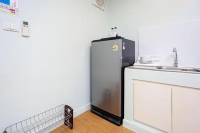 a black refrigerator in a kitchen with a sink at Signature Phuket Resort in Chalong