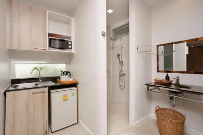 a small kitchen with a sink and a shower at Signature Phuket Resort in Chalong
