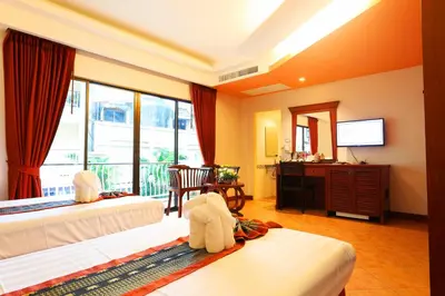a hotel room with two beds and a television at Baan Boa Resort in Patong Beach
