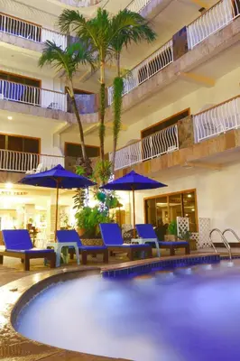 a pool in a hotel with blue chairs and umbrellas at Baan Boa Resort in Patong Beach