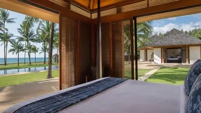 a bedroom with a bed and a view of the ocean at Jivana Beach Villas in Natai Beach