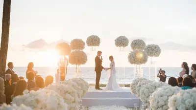 a bride and groom exchange vows at their wedding on the beach at Jivana Beach Villas in Natai Beach