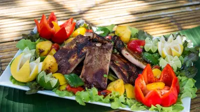 a plate of food with meat and vegetables on a table at Jivana Beach Villas in Natai Beach