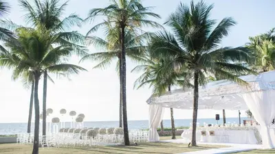 a wedding ceremony on the beach with palm trees at Jivana Beach Villas in Natai Beach