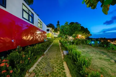 a garden next to a red and white building at Memory Karon Resort in Karon Beach