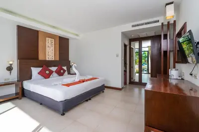 a bedroom with a bed and a television in it at Memory Karon Resort in Karon Beach