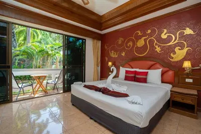 a bedroom with a bed with a swan on it at Memory Karon Resort in Karon Beach