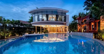 a house with a swimming pool in front of a building at Areca Resort and Spa in Kathu