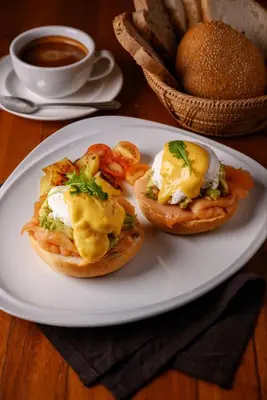 a plate with two breakfast sandwiches with eggs and tomatoes at Karon Phunaka Resort in Karon Beach