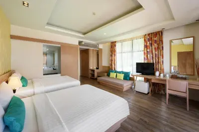 a hotel room with a large bed and a desk at Karon Phunaka Resort in Karon Beach