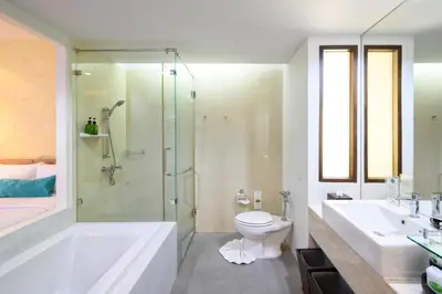 a bathroom with a shower and a toilet and a sink at Karon Phunaka Resort in Karon Beach
