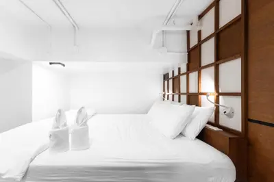 a bedroom with a white bed with white pillows at Book a Bed Poshtel - SHA Plus in Phuket Town