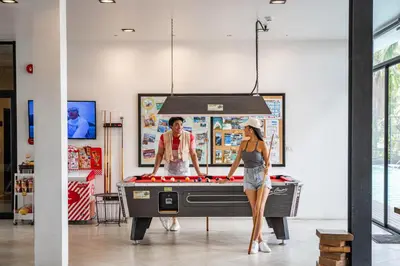 a man and a woman standing in front of a pool table at Book a Bed Poshtel - SHA Plus in Phuket Town