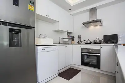 a kitchen with white cabinets and a stove at ViLLa JUNGLE 3 BEDROOMS in Kamala Beach