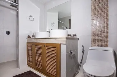 a white bathroom with a toilet and a sink at ViLLa JUNGLE 3 BEDROOMS in Kamala Beach